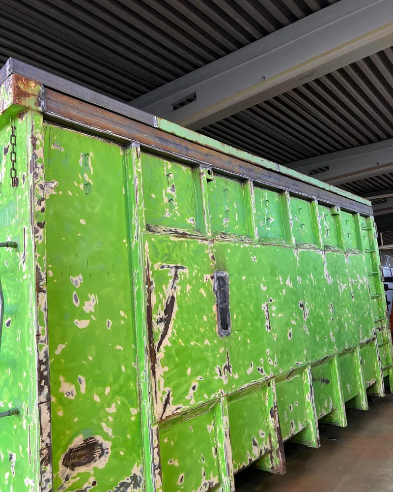 Renoverad grön container med ny överkant i stål och svetsad lagning