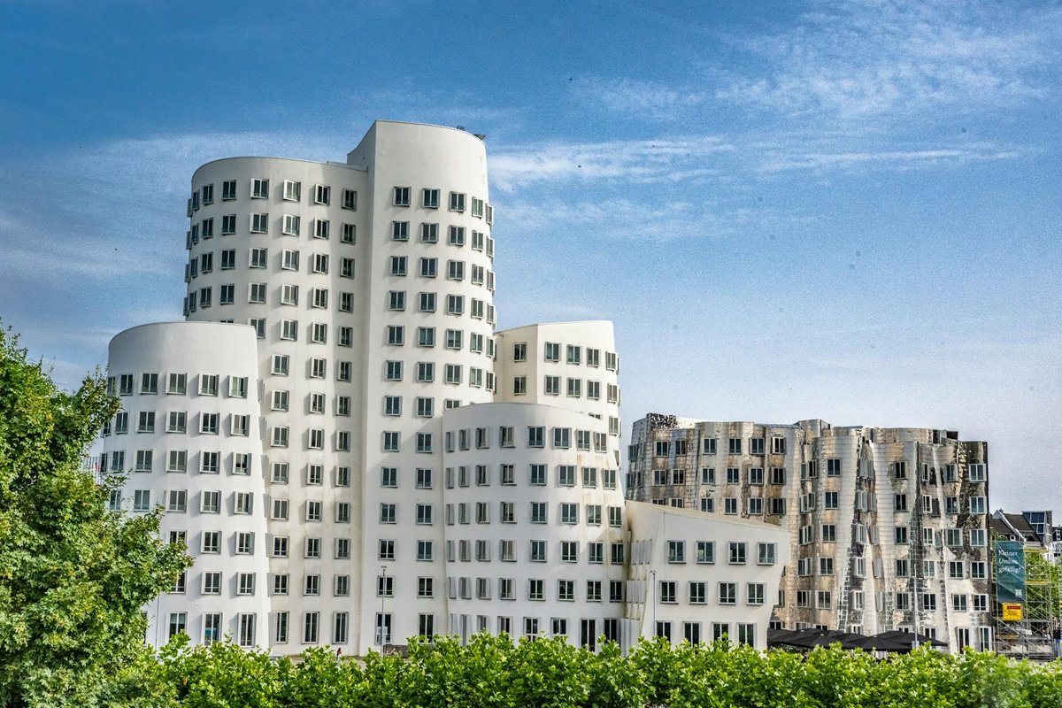 Modern byggnadsfasad med arkitektoniska detaljer i blankpolerat rostfritt stål.