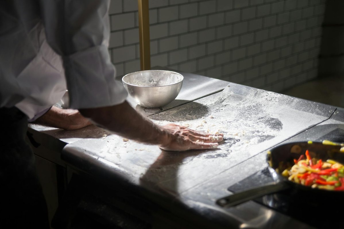 Modernt kommersiellt restaurangkök med hållbara arbetsbänkar och hyllor i rostfritt stål.