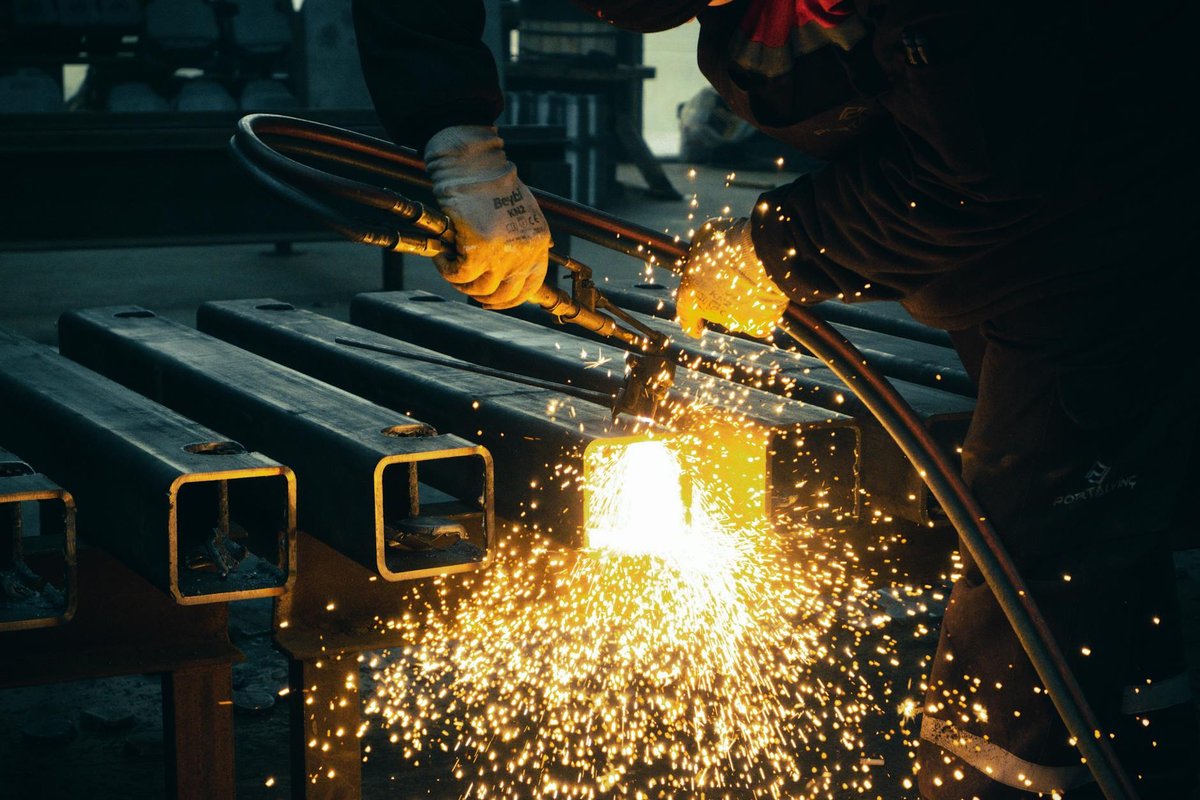 Professionell svetsare som svetsar en industriell ståltrappa med hög precision