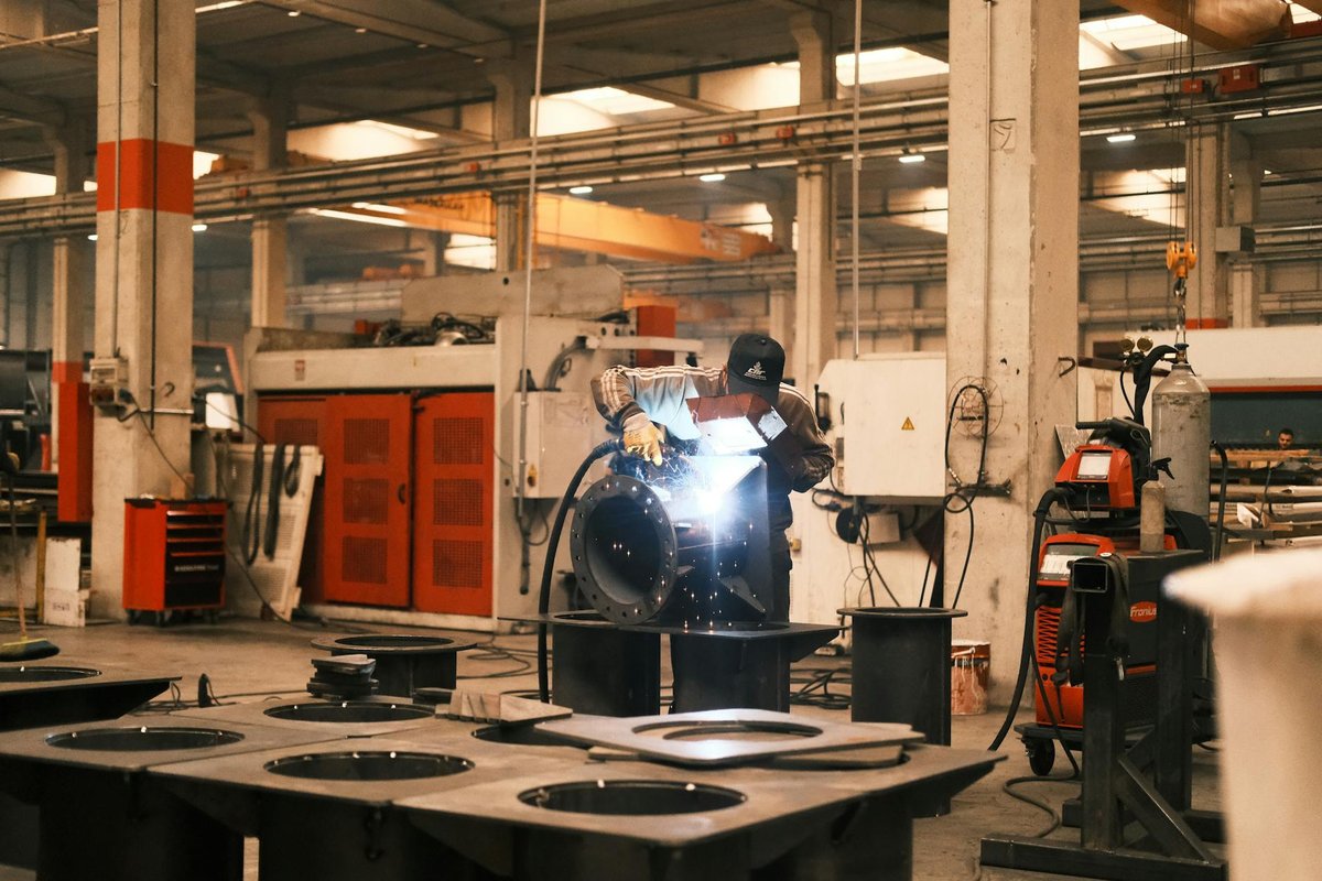 Erfaren smed som utför TIG-svetsning på ett rostfritt räcke i en verkstad
